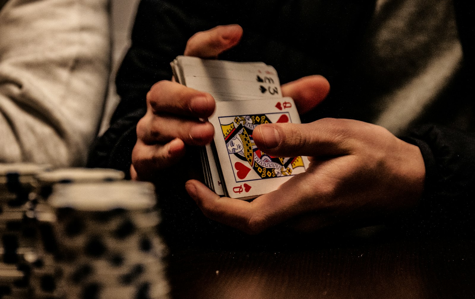 A hand holding up the king of spades playing card