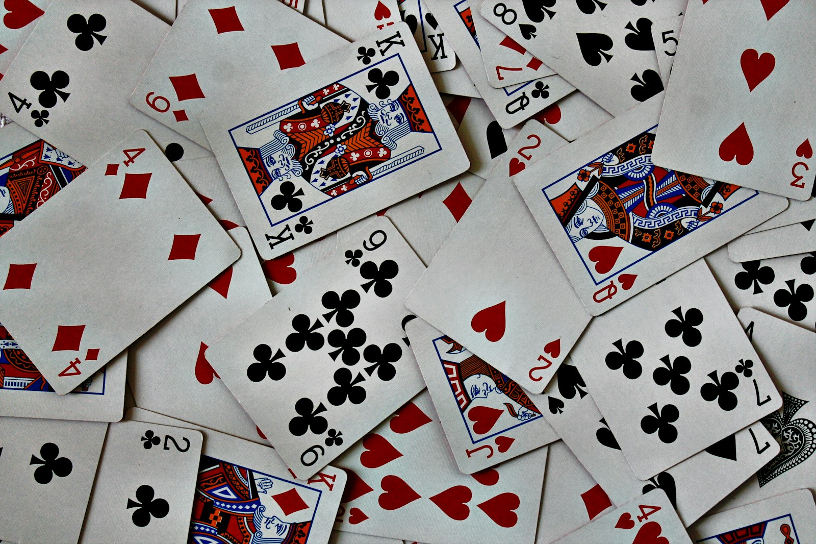 A large pile of playing cards stacked loosely on top of each other